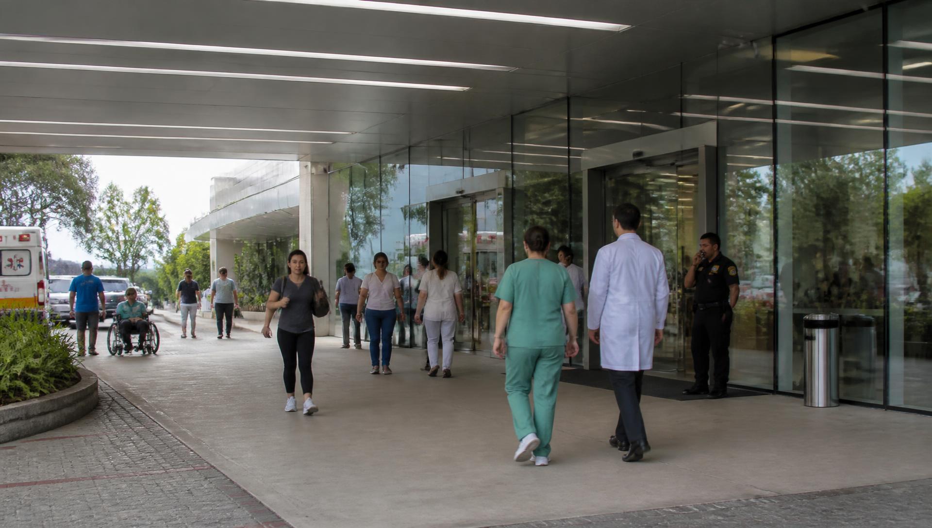 Pessoas entrando no hospital sendo identificadas na entrada principal
